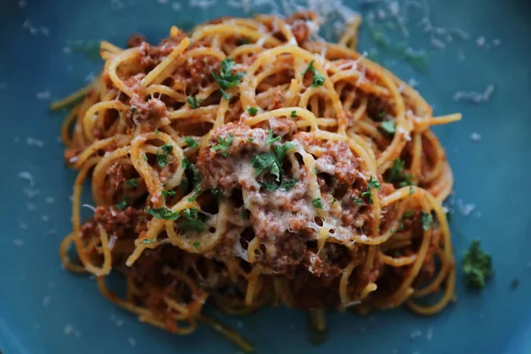 Spagetti Bolognese kıyma ve domates sosu ile parmesan peyniri ve fesleğen, İtalyan yemeği üstten görünüm ile süslenmiş