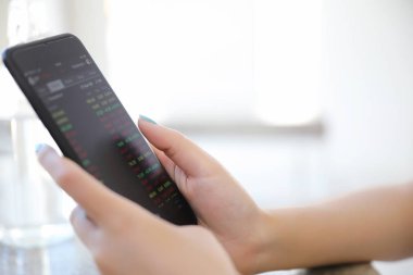 Kadın el smartphone Ticaret hisse senedi ve veriler kafede arka plan iş kavramı içinde tutarak yakından