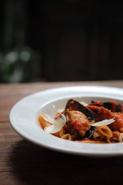 Penne makarna domates sosu arabiata ahşap arka plan vintage tarzı üzerinde deniz ürünleri ile