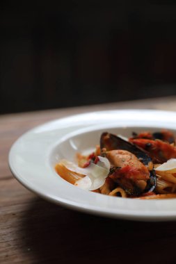 Penne makarna domates sosu arabiata ahşap arka plan vintage tarzı üzerinde deniz ürünleri ile