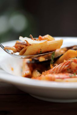 Penne makarna domates sosu arabiata ahşap arka plan vintage tarzı üzerinde deniz ürünleri ile