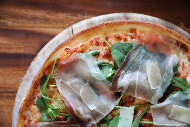 Pizza parma ham salata roket üzerinde ahşap masa arka plan ile domates sosu ile