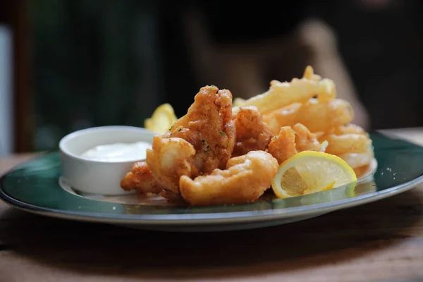 Fish and chips fried fish and potatoes on wood background vintage style