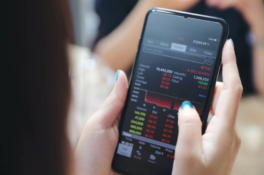 Kadın el smartphone Ticaret hisse senedi ve veriler kafede arka plan iş kavramı içinde tutarak yakından