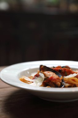 Penne makarna domates sosu arabiata ahşap arka plan vintage tarzı üzerinde deniz ürünleri ile