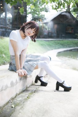 beyaz gömlek ve etek açık doğa vintage film tarzında oturan Asyalı Kız portresi