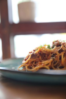 Parmesan peyniri ve fesleğenle süslenmiş kıyma ve domates soslu spagetti bolonez, İtalyan yemeği.