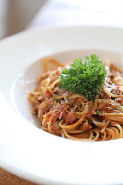 Parmesan peyniri ve fesleğenle süslenmiş kıyma ve domates soslu spagetti bolonez, İtalyan yemeği.