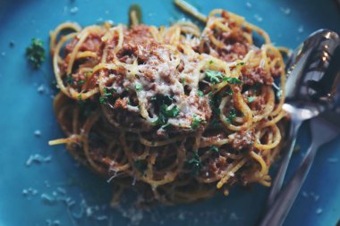 Spagetti Bolognese kıyma ve domates sosu ile parmesan peyniri ve fesleğen, İtalyan yemeği üstten görünüm ile süslenmiş