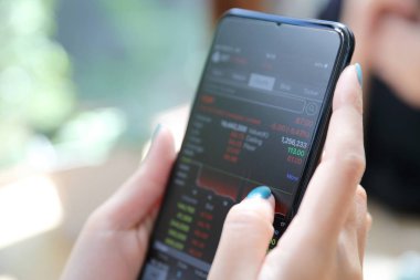 Kadın el smartphone Ticaret hisse senedi ve veriler kafede arka plan iş kavramı içinde tutarak yakından