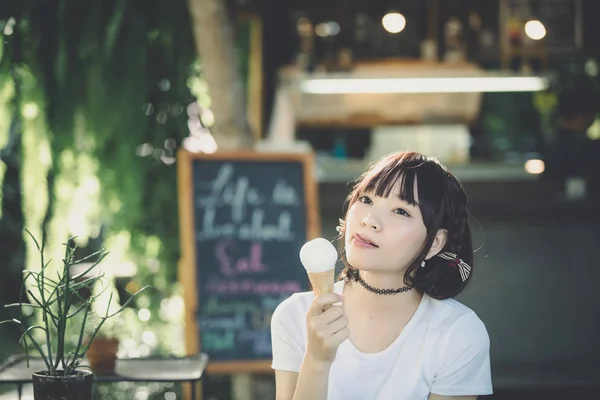 portrait of asian girl with white shirt and skirt eating ice cream vintage film style