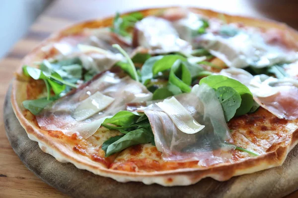 Pizza parma ham salata roket üzerinde ahşap masa arka plan ile domates sosu ile