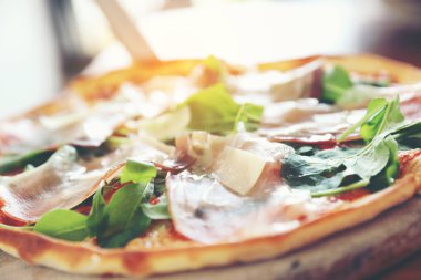 Pizza parma ham salata roket üzerinde ahşap masa arka plan ile domates sosu ile