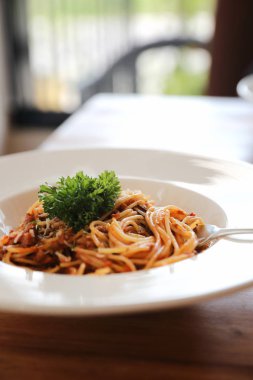 Parmesan peyniri ve fesleğenle süslenmiş kıyma ve domates soslu spagetti bolonez, İtalyan yemeği.