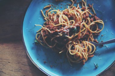 Spagetti Bolognese kıyma ve domates sosu ile parmesan peyniri ve fesleğen, İtalyan yemeği üstten görünüm ile süslenmiş