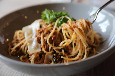Parmesan peyniri ve fesleğenle süslenmiş kıyma ve domates soslu spagetti bolonez, İtalyan yemeği.