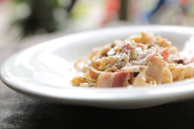 Makarna beyaz soslu domuz eti ve mantar mistik ışık ahşap arka plan üzerinde