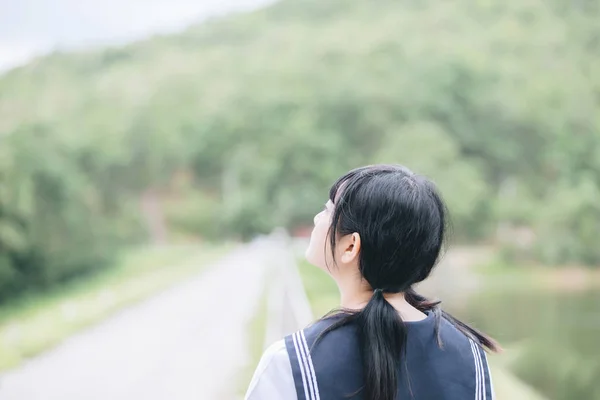 Portrait of asian japanese school girl costume looking at park outdoor film vintage style