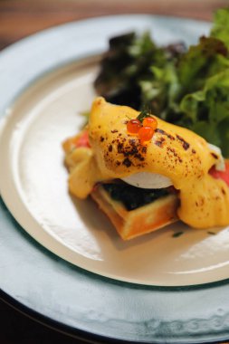 Kahvaltı yemek yumurta benedict, çılbır gözleme ve ahşap arka plan üzerinde füme somon ile sarı sos ile