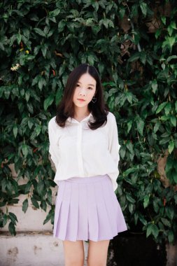 Açık şehir arka planında modern tarzda düşünen ve görünen genç bir kadın portresi.