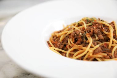 Parmesan peyniri ve fesleğenle süslenmiş kıyma ve domates soslu spagetti bolonez, İtalyan yemeği.