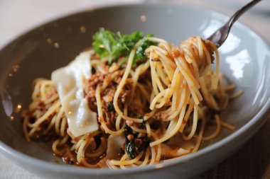 Parmesan peyniri ve fesleğenle süslenmiş kıyma ve domates soslu spagetti bolonez, İtalyan yemeği.