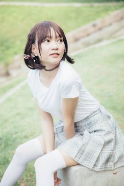 beyaz gömlek ve oturma ve açık kentsel vintage film tarzı arıyorum etek ile Asya Kız portresi