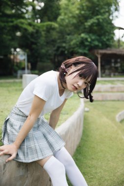 beyaz gömlek ve oturma ve açık kentsel vintage film tarzı arıyorum etek ile Asya Kız portresi