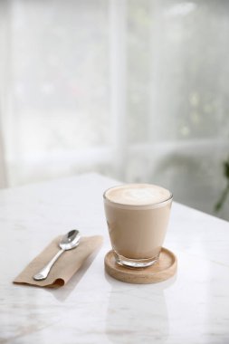 Kahve dükkanının ahşap masasındaki sütten yapılmış kapuçino ya da Latte sanat kahvesi.