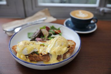 Yumurta benedict, tost ve kapuçino ahşap arka plan, İngiliz kahvaltısı ile haşlanmış yumurta