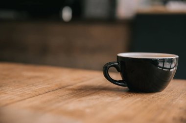 Kahve dükkanının ahşap masasındaki sütten yapılmış kapuçino ya da Latte sanat kahvesi.