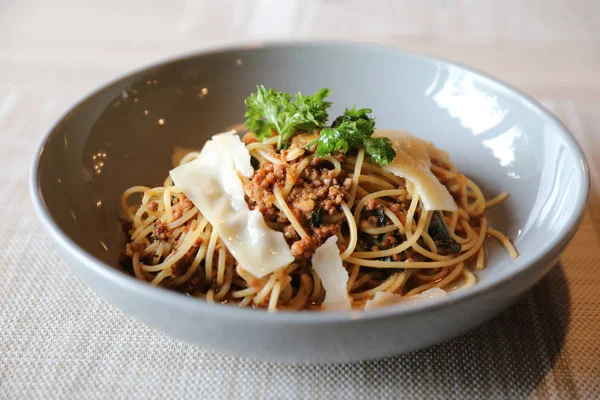 Parmesan peyniri ve fesleğenle süslenmiş kıyma ve domates soslu spagetti bolonez, İtalyan yemeği.