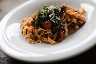 Koyu tonu mistik ışık tarzı ahşap arka plan üzerinde sığır eti ve domates soslu makarna Fettuccine Bolognese