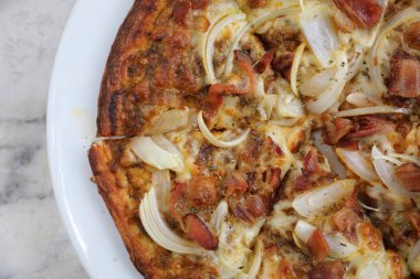 Gevrek domuz pastırması soğan açık masa üzerinde pizza