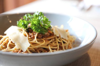 Parmesan peyniri ve fesleğenle süslenmiş kıyma ve domates soslu spagetti bolonez, İtalyan yemeği.