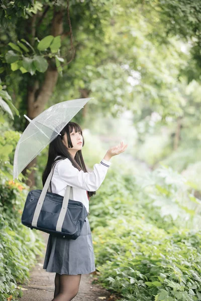 在雨中漫步在自然人行道上的亚洲学校女孩肖像 — 图库照片