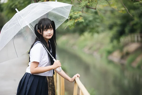 在雨中漫步在自然人行道上的亚洲学校女孩肖像 — 图库照片