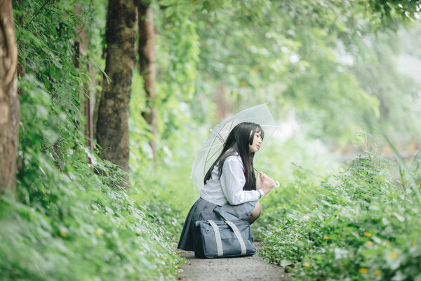 Portrait of asian japanese school girl costume looking at park outdoor film vintage style