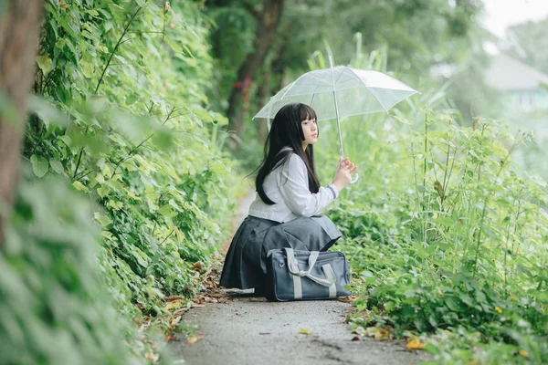 在雨中漫步在自然人行道上的亚洲学校女孩肖像 — 图库照片