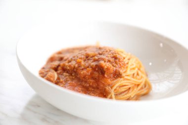 Parmesan peyniri ve fesleğenle süslenmiş kıyma ve domates soslu spagetti bolonez, İtalyan yemeği.