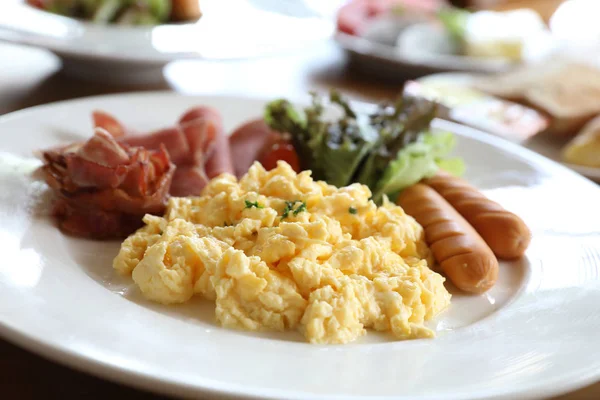 朝食のスクランブルエッグとベーコン ソーセージと木の背景にサラダ — ストック写真
