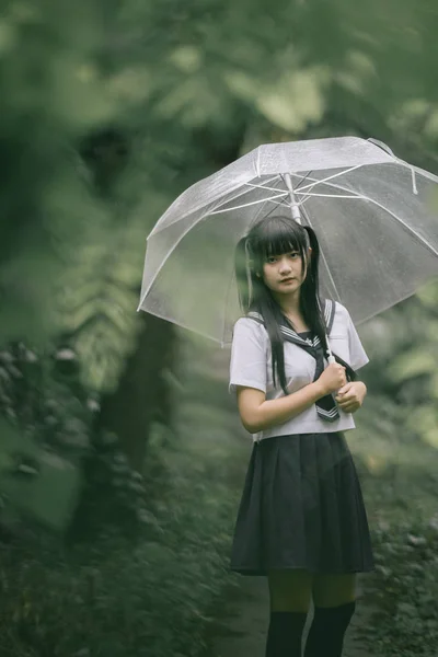 在雨中漫步在自然人行道上的亚洲学校女孩肖像 — 图库照片