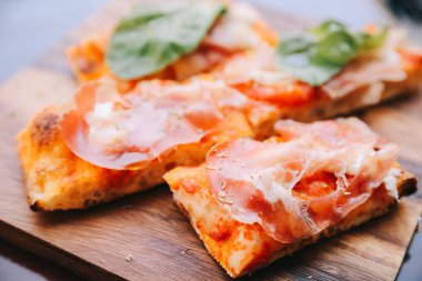Parma ham salata roket ve parmesan pizza koyu ahşap zemin üzerine kapatın. Italyan Mutfagi