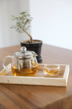 Ahşap masa üzerinde çaydanlık içecek ile sıcak çay fincanı