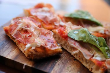 Parma ham salata roket ve parmesan pizza koyu ahşap zemin üzerine kapatın. Italyan Mutfagi