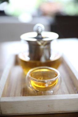 Ahşap masa üzerinde çaydanlık içecek ile sıcak çay fincanı