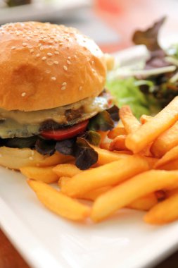 Sığır eti Hamburger patates kızartması ve salata ahşap arka plan üzerinde