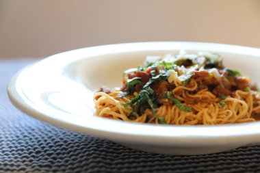 Parmesan peyniri ve fesleğenle süslenmiş kıyma ve domates soslu spagetti bolonez, İtalyan yemeği.