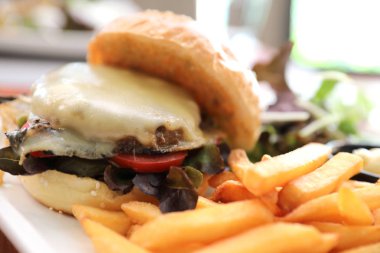 Sığır eti Hamburger patates kızartması ve salata ahşap arka plan üzerinde