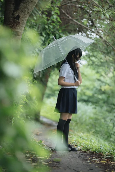 在雨中漫步在自然人行道上的亚洲学校女孩肖像 — 图库照片